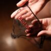 Close view of red Hotwife embroidery through black mesh
