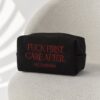 Fuck First Care After embroidered black pouch on a soft chair